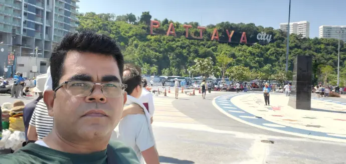 at Pattaya City viewpoint Thailand with iconic hillside sign, tourists, and sunny day backdrop